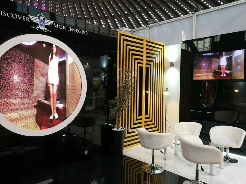 Lounge zona sa belim foteljama i staklenim stolovima